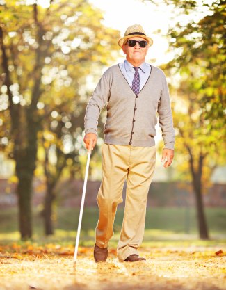 Blind man using walking stick.
